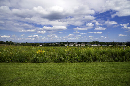 Town under the sky across the tall grass