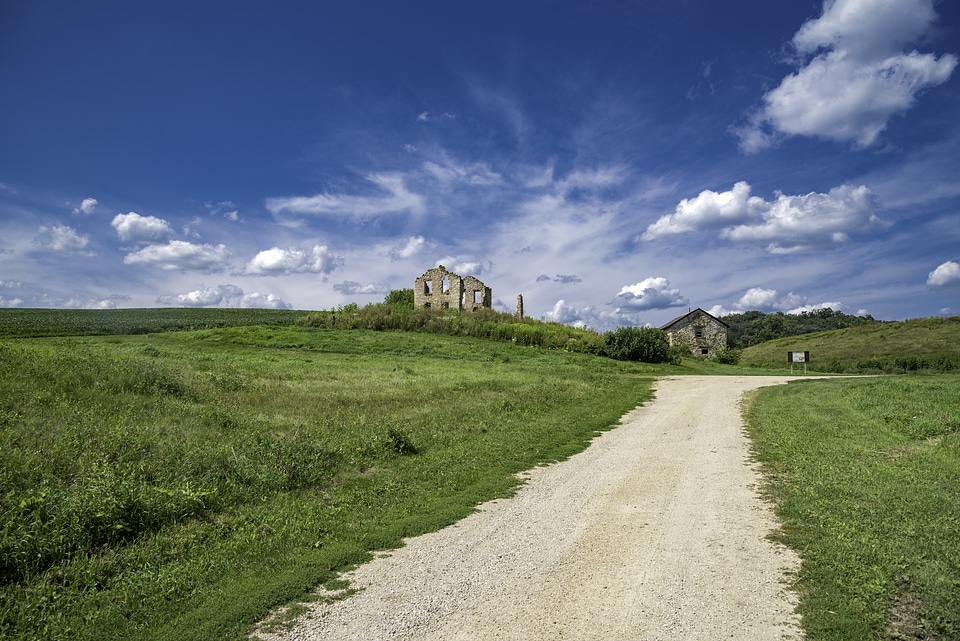 Path to abandoned homestead under blue skies
