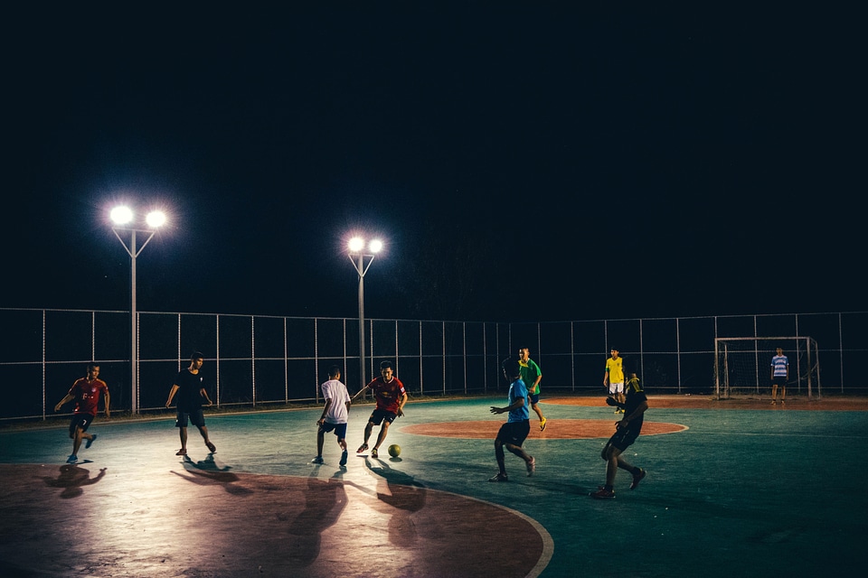 People playing soccer under the streetlamps