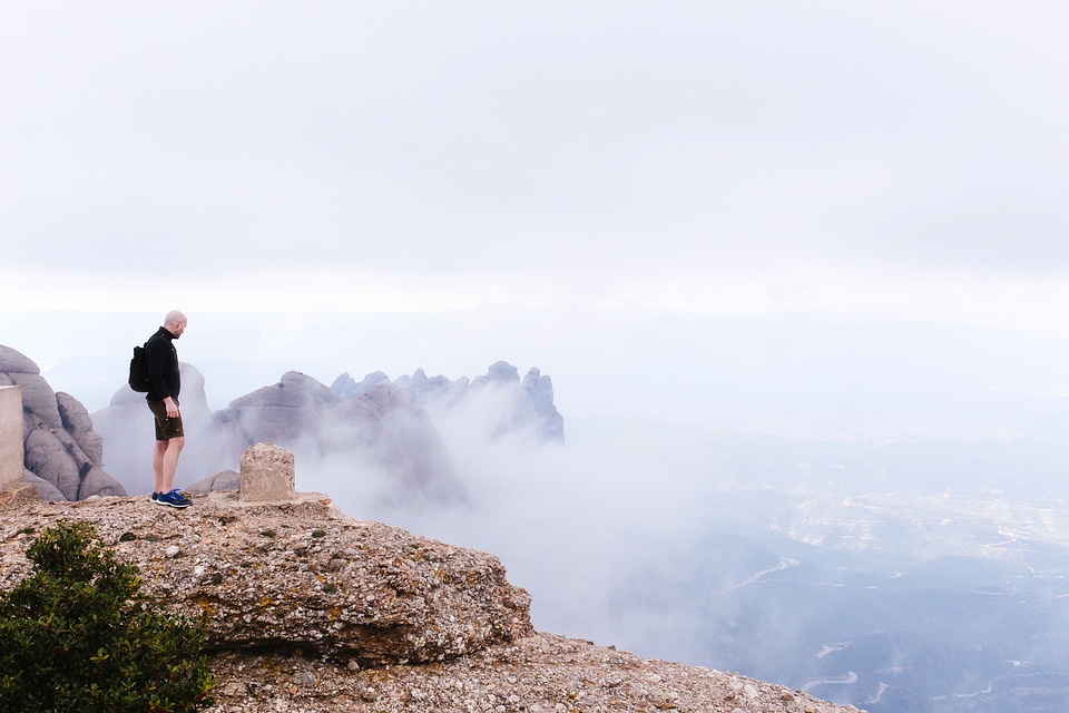 Man standing Landmark marker on the high mountains in Montserrat, Spain