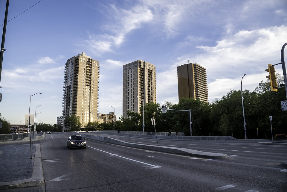 Car on the road with three buildings in the background in Winnipeg