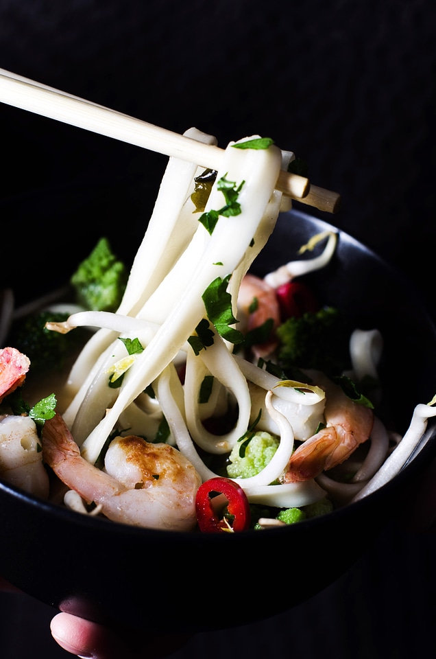 Chopsticks holding seafood noodles