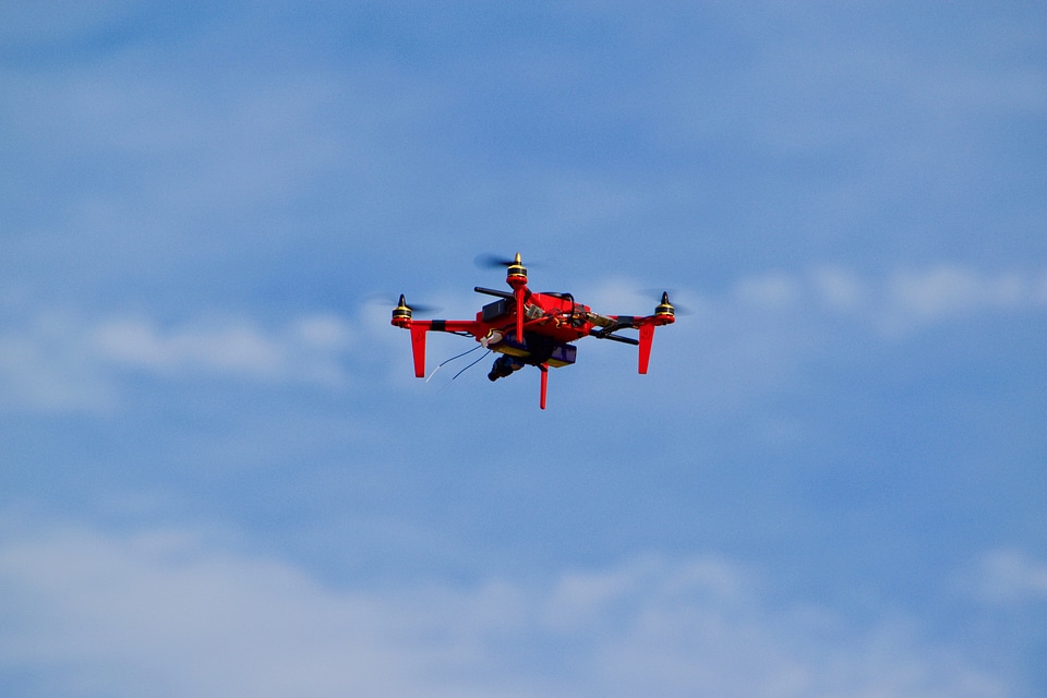 Red Drone Flying in the blue Sky