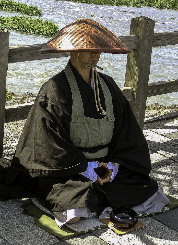 Monk waiting for offerings in Kyoto, Japan
