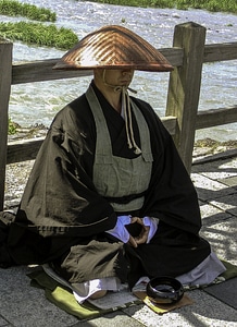 Monk waiting for offerings in Kyoto, Japan photo