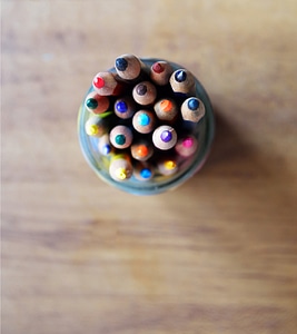 Colored pencils pointing up in glass photo
