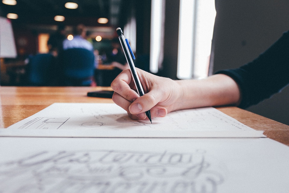 Hand writing paper with pen