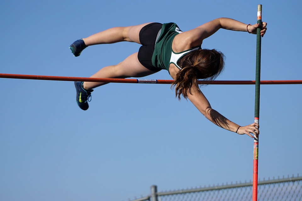 Woman Pole Vaulting over the bar photo