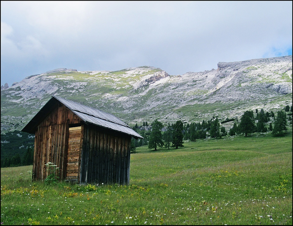 Lone Cabin on grassland by mountains