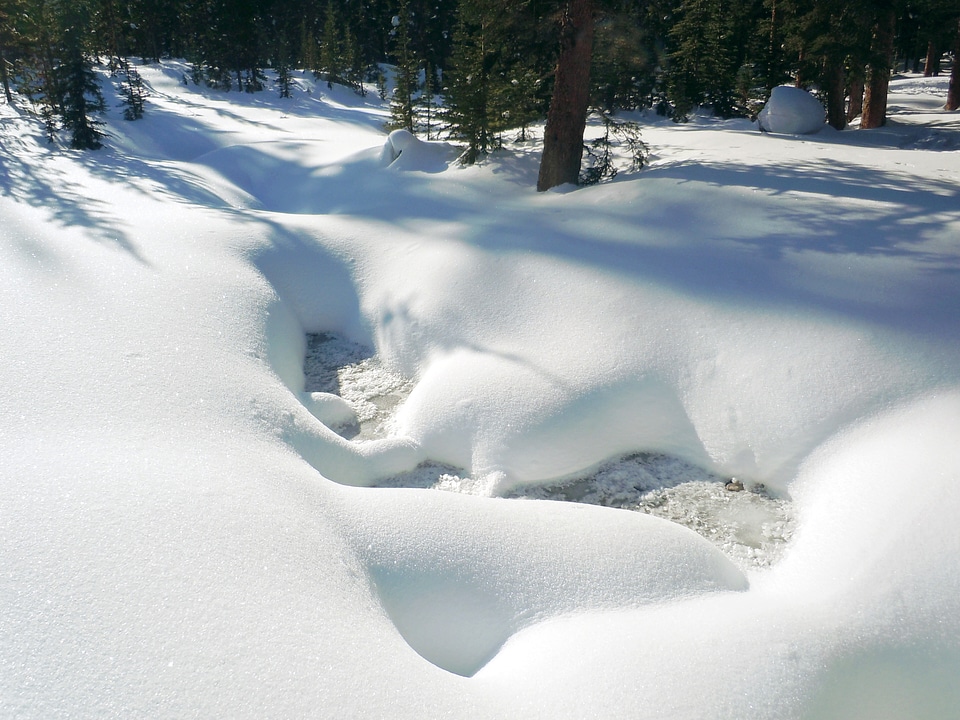 Frozen creek in deep snow