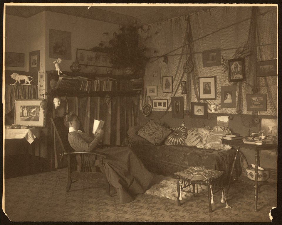 Miss Foster, faculty at Carlisle Indian School, full length, reclining in chair, reading a book LCCN2008678878