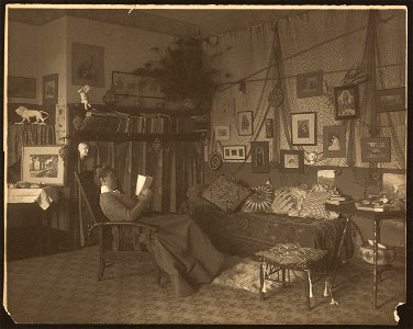 Miss Foster, faculty at Carlisle Indian School, full length, reclining in chair, reading a book LCCN2008678878