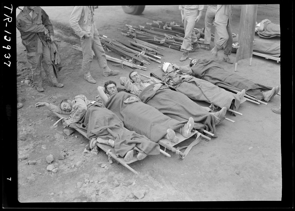 Marines, injured in Iwo Jima fighting, await evacuation to Guam by plane. - NARA - 520988
