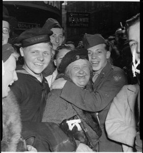 Jubilant American soldier hugs motherly English woman and victory smiles light the faces of happy service men and... - NARA - 531280