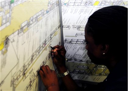 US Navy 090703-N-8607R-005 Aviation Support Equipment Technician Airman Daisy Calliste, attached to Aviation Intermediate Maintenance Department (AIMD), plots shipboard compartments during general quarters onboard USS Bonhomme