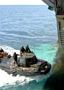 US Navy 090708-N-9950J-006 Sailors assigned to Assault Craft Unit One (ACU-1), Detachment Western Pacific (WESTPAC), guide a lighter amphibious re-supply cargo (LARC) vehicle into the well deck of the forward-deployed amphibio