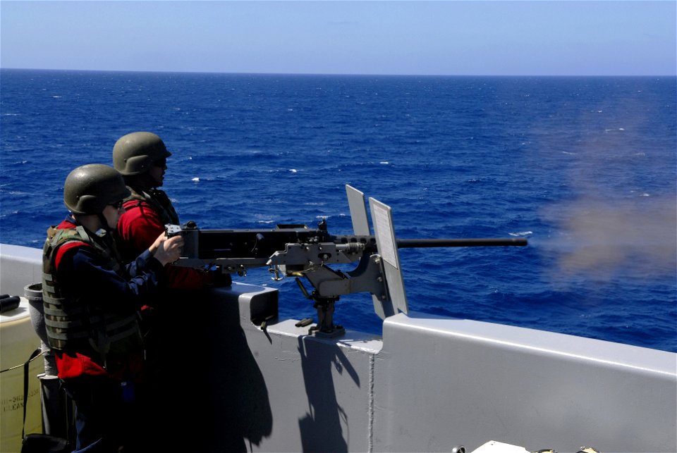 US Navy 090705-N-2475A-310 Culinary Specialist 3rd Class Nicholas Zaricor, from Vancouver, Wash., fires a .50 cal machine gun with Aviation Ordnanceman Airman Marcus Gilmore, from Colorado Springs, Colo photo