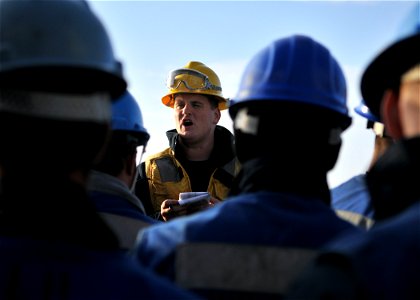 US Navy 111202-N-ZF681-004 Boatswain's Mate 2nd Class Jason Connole relays orders to line handlers aboard the guided-missile destroyer USS Halsey (