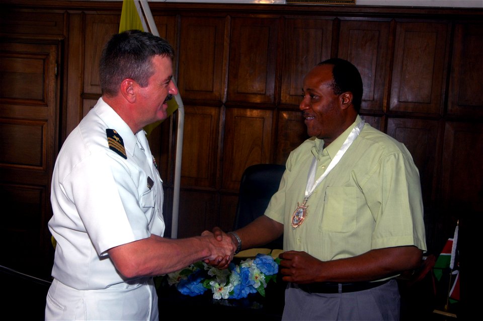 US Navy 071019-N-4014G-380 Cmdr. Robert Hall Jr., commanding officer of guided-missile destroyer USS Porter (DDG 78), presents a command coin to the Mayor of Mombassa, Kenya, Hamisi Mwindani