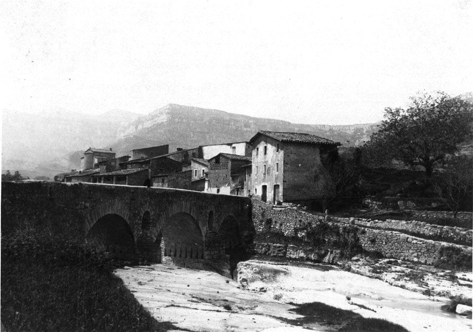 Molí de Dalt de l'Abella amb un pont i el riu en primer terme