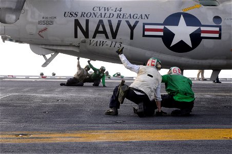 US Navy 090706-N-3610L-010 Two final checkers give flight deck training to two trainees as they perform a final check on an E-2C Hawkeye photo