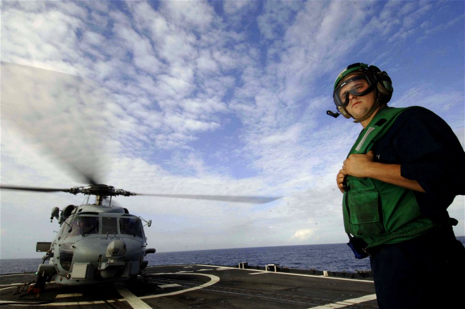 US Navy 061021-N-5330L-497 Aviation Electronics Technician 3rd Class Steven Sutton assigned to Helicopter Anti-Submarine Squadron Light Four Six (HSL-46) directs a landing aboard the guided-missile cruiser USS Anzio's (CG 68)