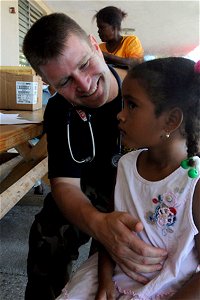 US Navy 081013-N-7955L-018 U.S. Public Health Service Lt. Cmdr. John Condojani, a medical augmentee embarked aboard the amphibious assault ship USS Kearsarge (LHD 3), examines a child at Las Calderas Naval Base