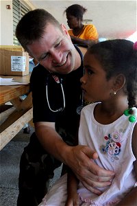 US Navy 081013-N-7955L-018 U.S. Public Health Service Lt. Cmdr. John Condojani, a medical augmentee embarked aboard the amphibious assault ship USS Kearsarge (LHD 3), examines a child at Las Calderas Naval Base photo