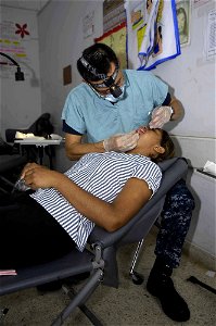 US Navy 090711-F-7923S-120 Lt. Cmdr. Jeffrey Lowe, a Navy dentist embarked aboard the Military Sealift Command hospital ship USNS Comfort (T-AH 20), cleans a patient's teeth during a Continuing Promise 2009 medical service proj
