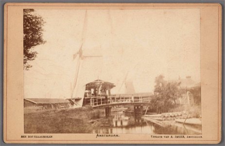 Molen De Steur aan de Steurweg gezien van het bruggetje dat toegang geeft tot de werf van molen De Witte Duif. Op de achtergrond Het Leidsche Wapen. Links de berm van de Buitensingelweg