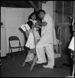 Manzanar Relocation Center, Manzanar, California. Young evacuee dentist and his assistant in their . . . - NARA - 538148 photo