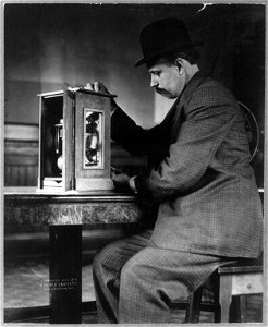 Man seated with a stamp vending machine LCCN2003654889 photo