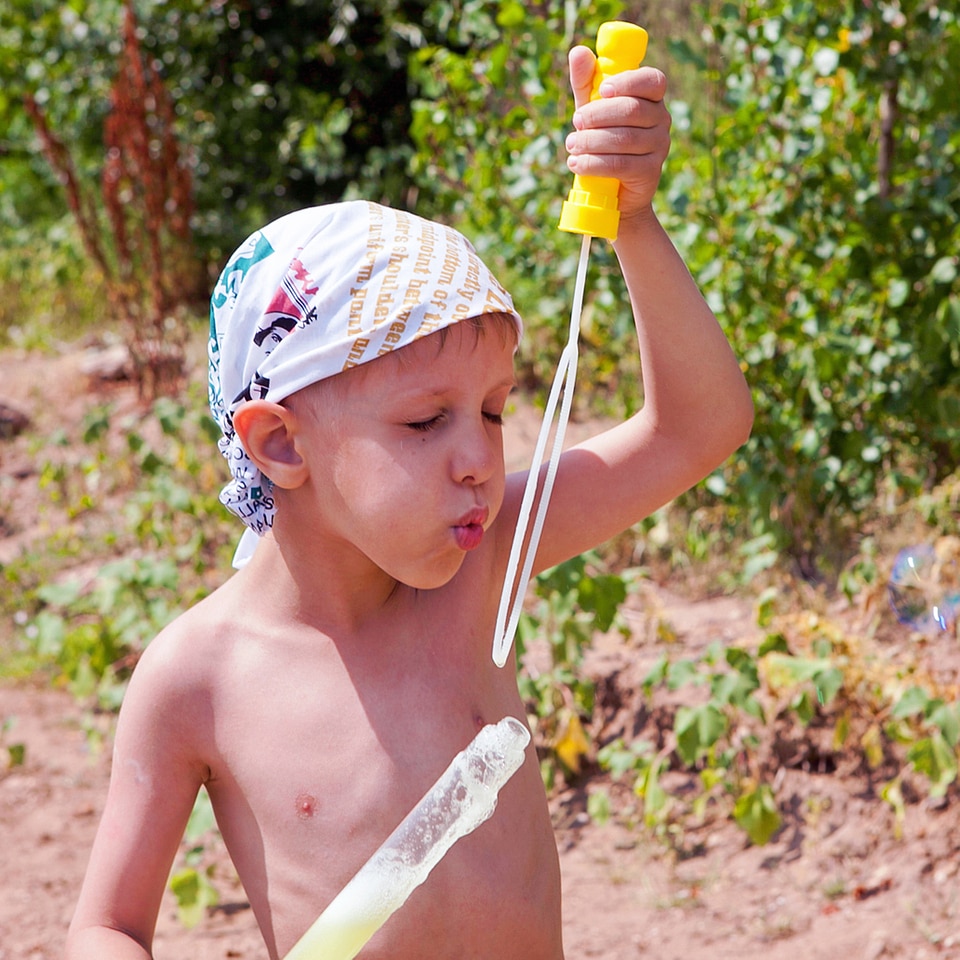 Boy blowing soap bubbles photo