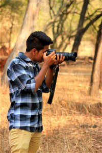 Man Holding Black Dslr Camera photo