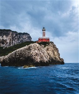 Red Lighthouse On Top Of Hills Beside Sea photo