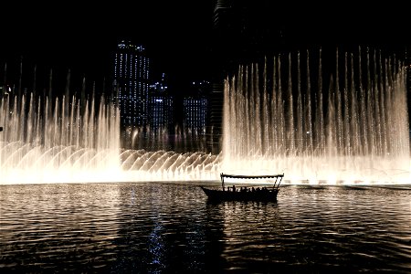Silhouette Of A Boat On A Body Of Water With Fountain photo