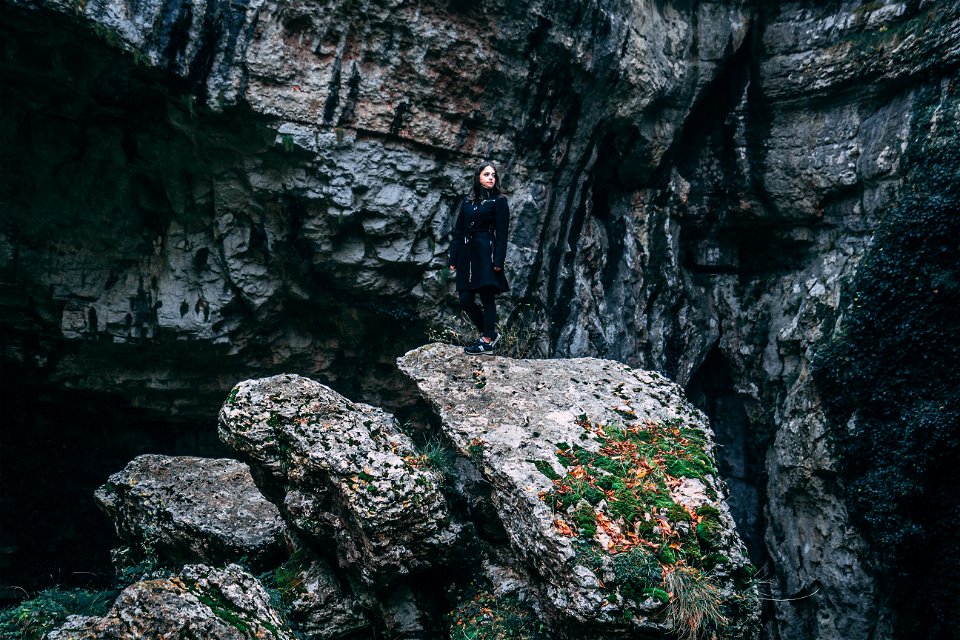 Photo Of Woman In Black Outfit Standing On Rock
