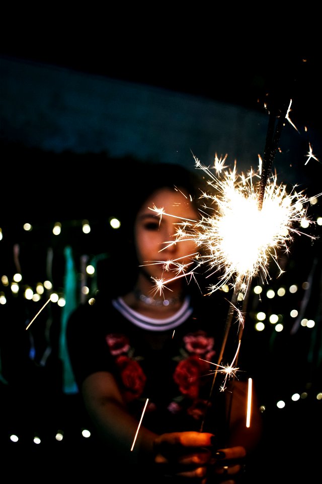 Woman Holding Sparkle During Nighttime