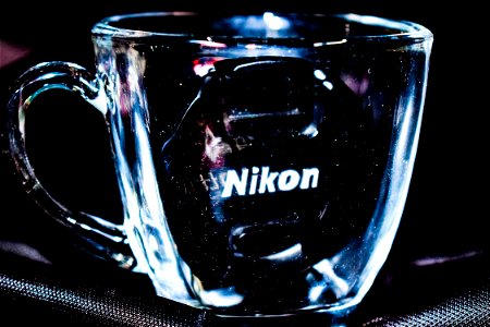 Close Up Photo Of Clear Glass Mug With Nikon Lens Cap photo