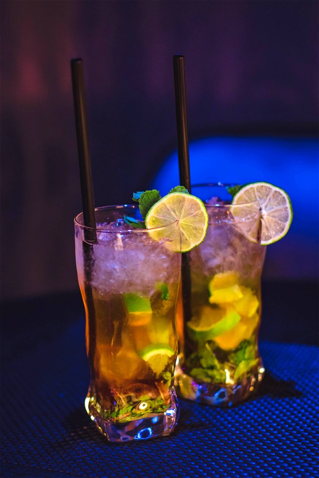 Two Clear Drinking Glass With Juice And Black Straw