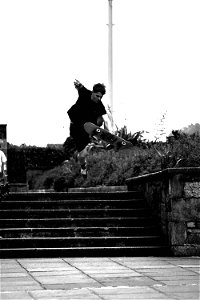 Grayscale Photo Of Man Doing Trick On Skateboard On Park photo