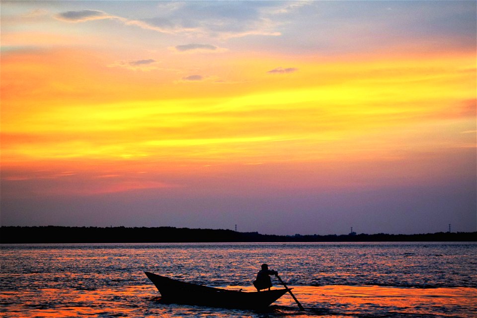 Silhouette Of Man On Boat In Water