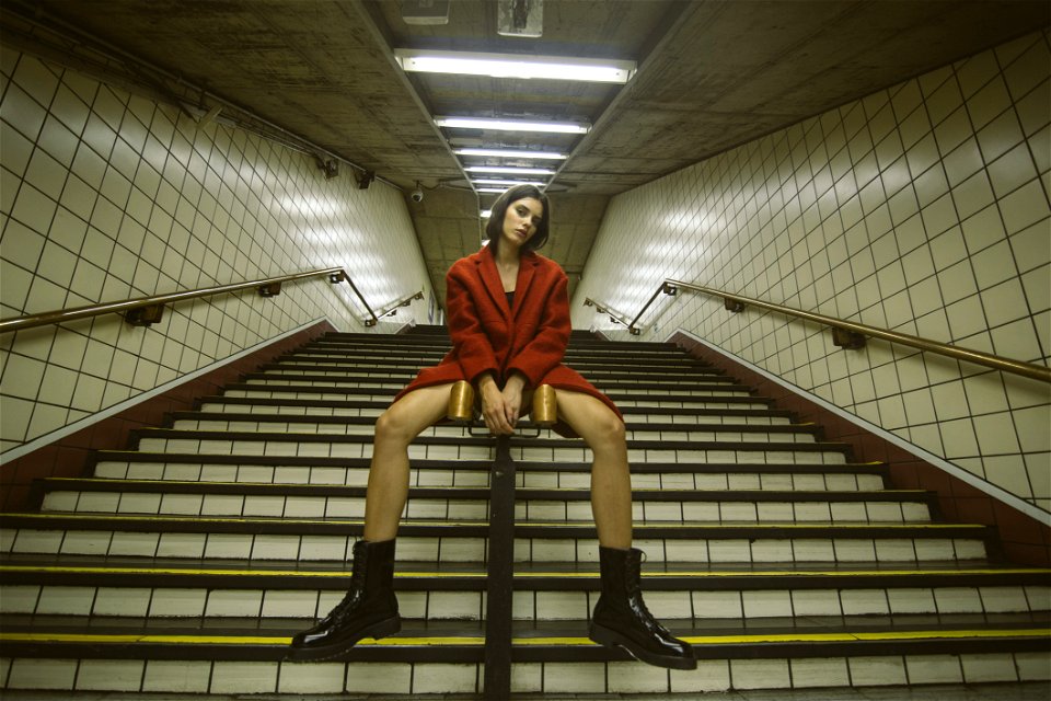 Woman Sitting On Handrail With Both Hand On Front