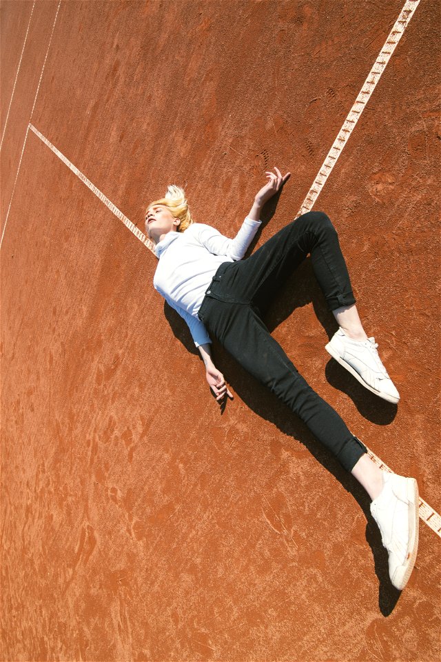 Woman Lying Down On A Brown Concrete Surface