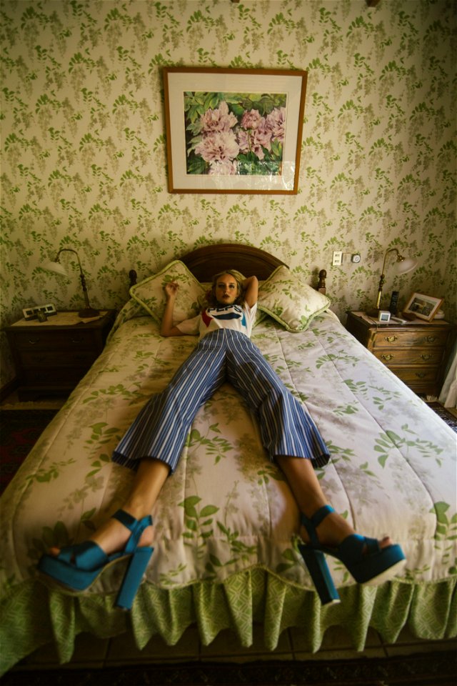 Woman In White Shirt Lying On White And Green Bed