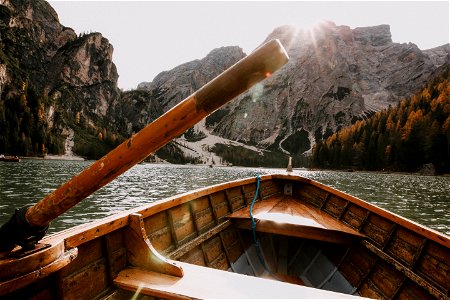 Brown Wooden Canoe On Body Of Water Near Mountain photo