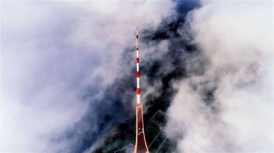 Aerial Photography Of Red And White Striped Tower Near Clouds photo
