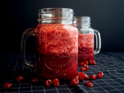 Mason Jar Filled With Cranberry Juice On Black And White Checked Cloth photo