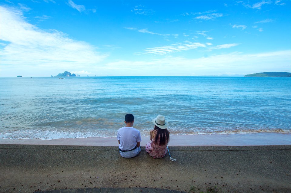 Man And Woman Sitting On Seashore photo