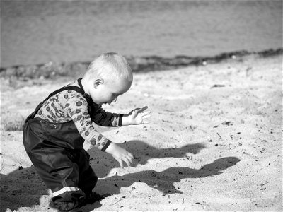 Grayscale Photography Of Toddler On Beach Sand photo